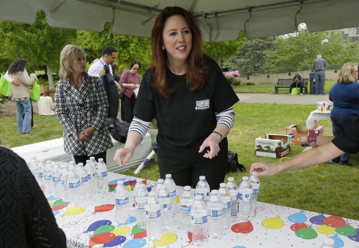 In this May 4, 2016 photo, Washington Secretary of State Kim Wyman hands out bottled water to state employees at the Capitol in Olympia, Wash. Wyman, the lone statewide elected Republican in Washington state, is facing Democrat Tina Podlodowski, a former Microsoft manager and adviser to Seattle Mayor Ed Murray as she seeks a second term in office. (AP Photo/Ted S.