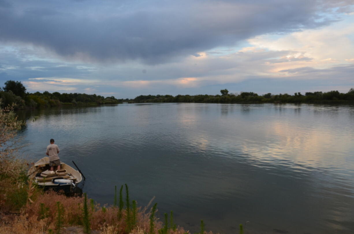 A fisherman stands on his boat looking across the Snake River near Homedale, Idaho, on Sept. 25, 2014. The first attempt to delist one of the species of Columbia Basin salmon and steelhead protected under the Endangered Species Act has been denied by federal authorities.