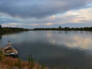 A fisherman stands on his boat looking across the Snake River near Homedale, Idaho, on Sept. 25, 2014. The first attempt to delist one of the species of Columbia Basin salmon and steelhead protected under the Endangered Species Act has been denied by federal authorities.