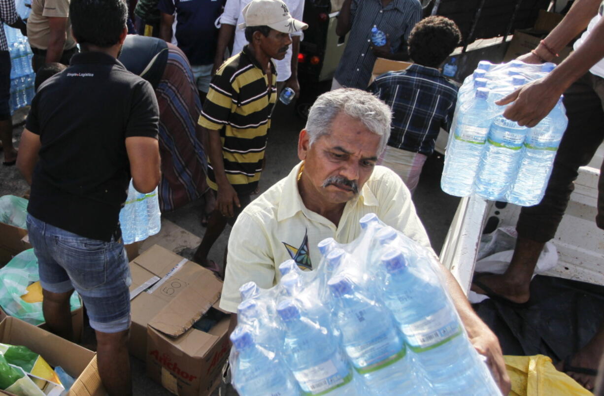 Sri Lankan volunteers unload bottles of drinking water  for distributing to the flood victims in Wellampitiya on the out skirts of Colombo, Sri Lanka, on Friday.