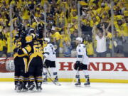 Pittsburgh Penguins&#039; Ben Lovejoy (12) and Carl Hagelin (62) swarm Nick Bonino after his game-winning goal against the San Jose Sharks during the third period in Game 1 of the Stanley Cup final series Monday, May 30, 2016, in Pittsburgh.