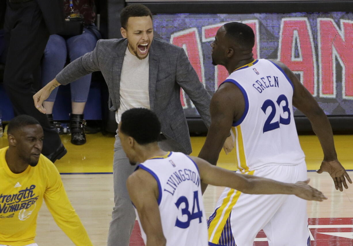 Golden State Warriors guard Stephen Curry, top left, celebrates with guard Ian Clark, bottom left, forward Draymond Green (23) and guard Shaun Livingston (34) during the second half in Game 2 of a second-round NBA basketball playoff series against the Portland Trail Blazers in Oakland, Calif., Tuesday, May 3, 2016. The Warriors won 110-99.