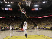 Portland Trail Blazers guard Allen Crabbe dunks in front of Golden State Warriors guard Shaun Livingston during the second half in Game 2 of a second-round NBA basketball playoff series in Oakland, Calif., Tuesday, May 3, 2016. The Warriors won 110-99.