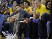 Golden State Warriors guard Stephen Curry, center left, sits on the bench during the first half in Game 2 of a second-round NBA basketball playoff series between the Warriors and the Portland Trail Blazers in Oakland, Calif., Tuesday, May 3, 2016.