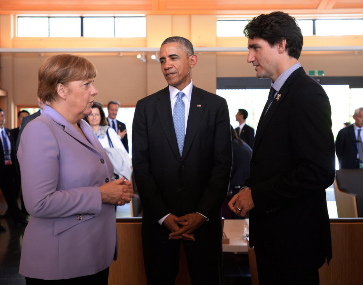 Prime Minister Justin Trudeau, right, talks with German Chancellor Angela Merkel, left, and U.S. President Barack Obama as they visit the Ise Grand Shrine in Ise, Japan during the G-7 Summit on Thursday.