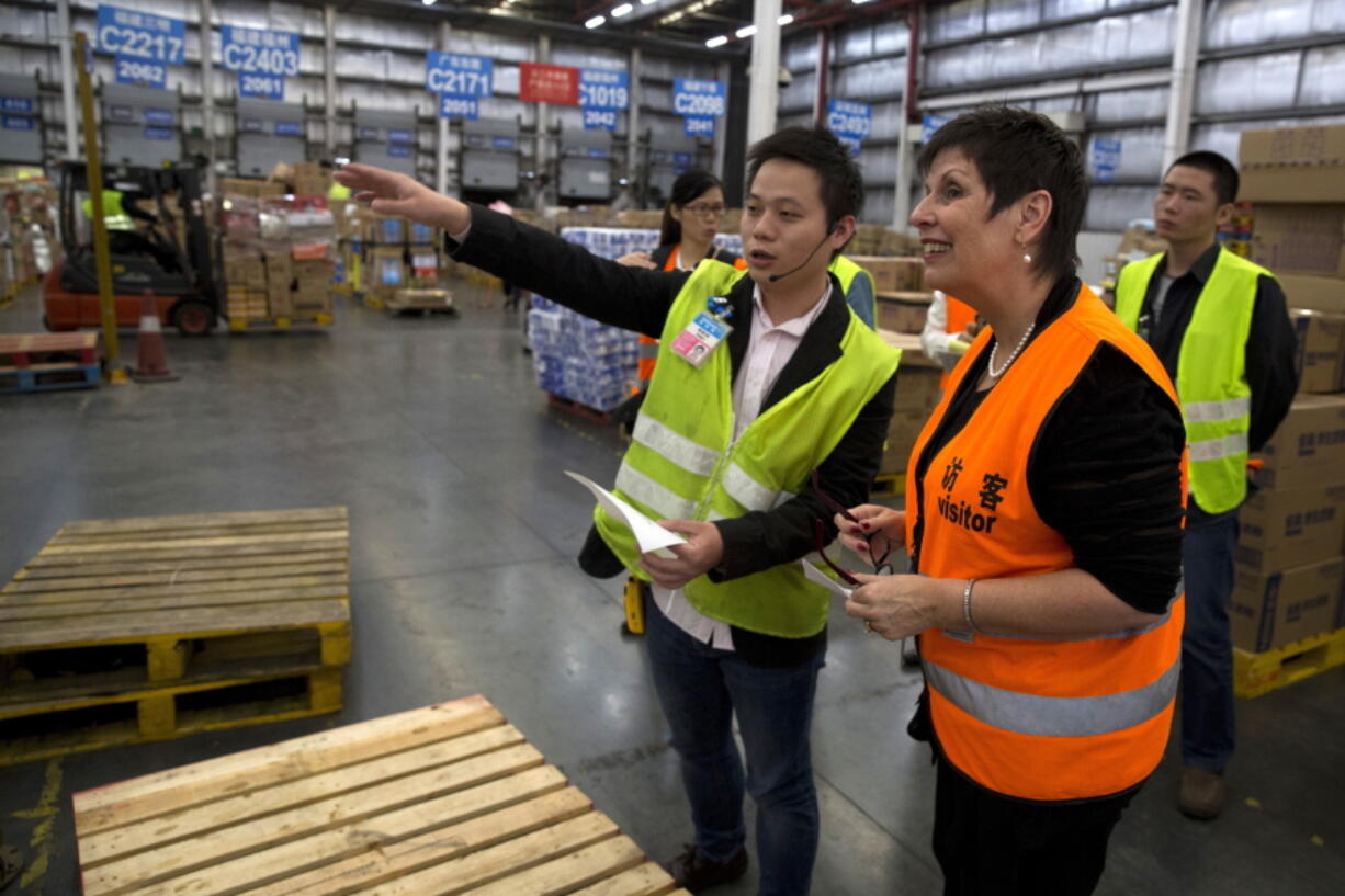 Lesley Smith, foreground right, senior vice president of the supply chain at Wal-Mart China, talks to a worker at a distribution center in Shenzhen, in southern China&#039;s Guangdong province. Wal-Mart is centralizing its food distribution to cut costs and improve the quality of goods.