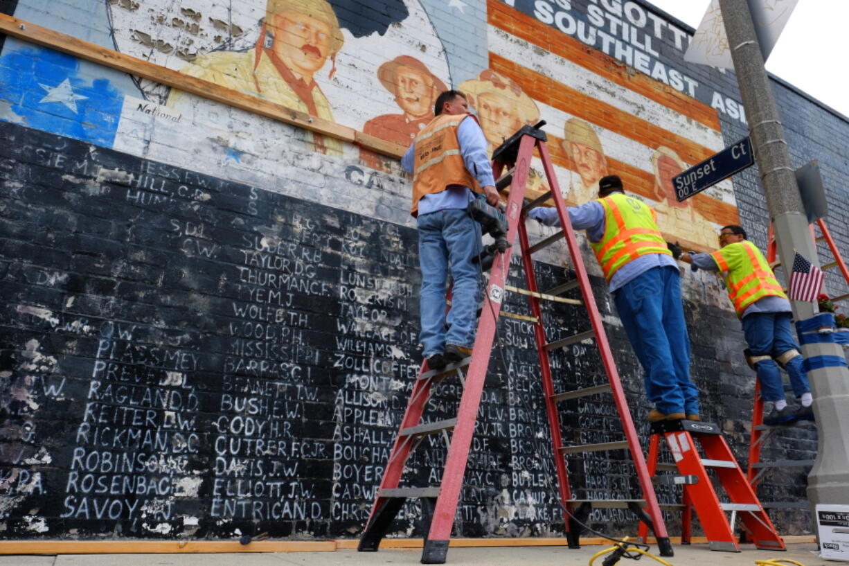 Metropolitan Transit Authority workers prepare to cover a vandalized war memorial Monday in the Venice Beach area of Los Angeles. The memorial had to be covered after authorities determined it was too badly damaged by graffiti to be quickly repaired.