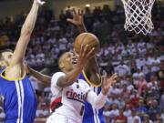 Portland Trail Blazers guard Damian Lillard, right, shoots over Golden State Warriors center Andrew Bogut, left, during the second half of Game 4 of an NBA basketball second-round playoff series Monday, May 9, 2016, in Portland, Ore. The Warriors won 132-125.