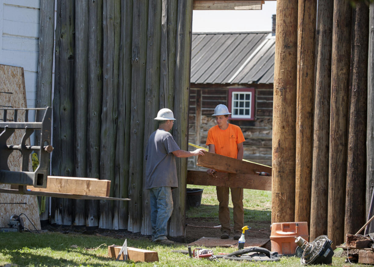 Jim Davis, left, and Bryce Ausland of the Ausland Group talk as they prepare to install new pickets on May 12 at Fort Vancouver National Historic Site.