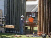 Jim Davis, left, and Bryce Ausland of the Ausland Group talk as they prepare to install new pickets on May 12 at Fort Vancouver National Historic Site.