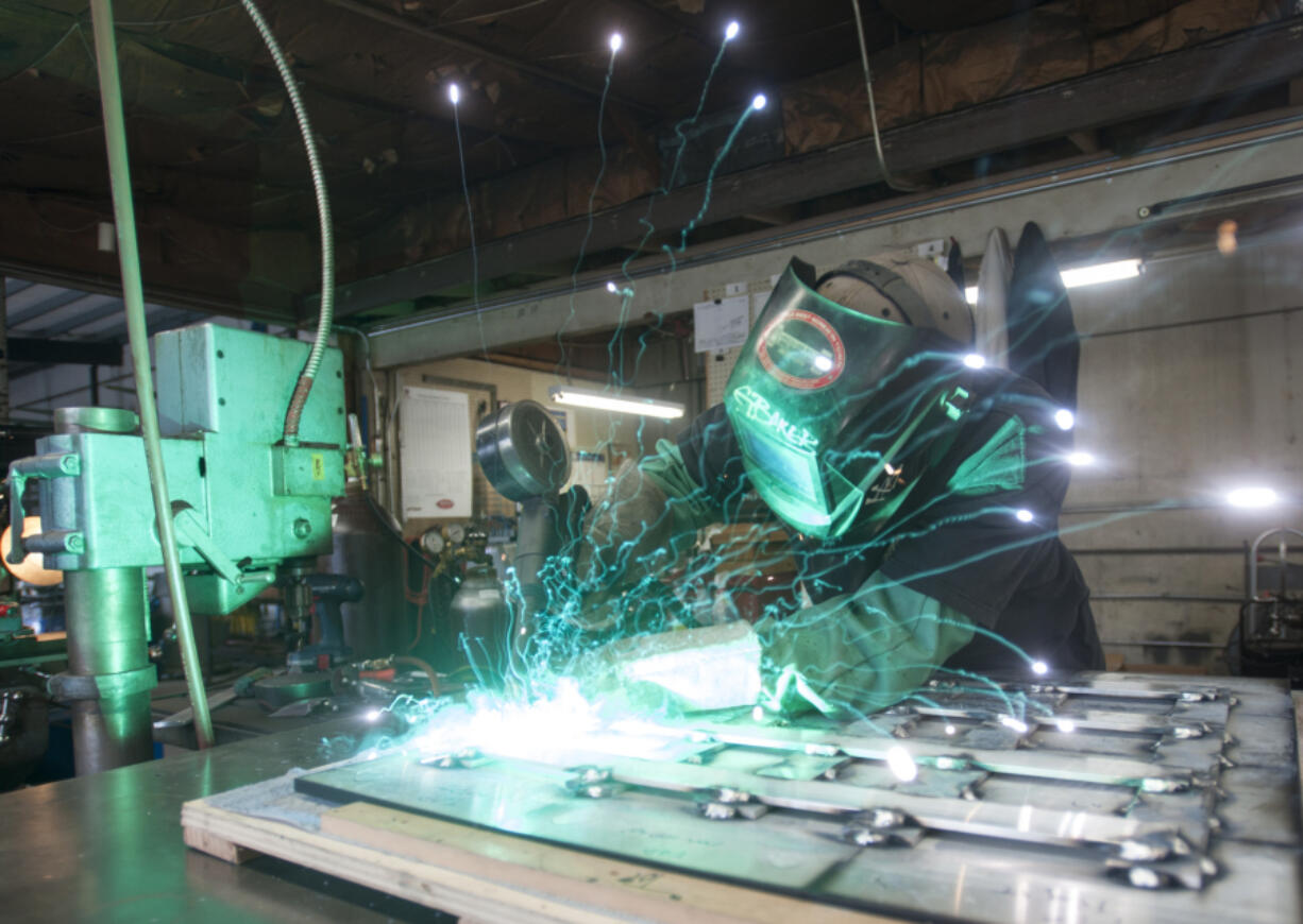 Gary Baker welds a section of a plaque at Vancouver Bolt and Supply that will be part of a Vietnam memorial.