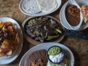 Nachos with taco beef, from left, are seen with steak fajitas as well as a crispy shell chicken taco with rice and beans at The Original Taco House in Vancouver.