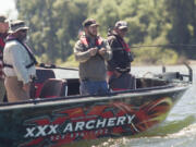 Veteran Jason Royse reels in a line Sunday morning during Operation Salmon Salute near Ridgefield. Royse is joined by other veterans, from left, Matt Wirkkla, Anthony Cavenaugh and Jason Dodge.