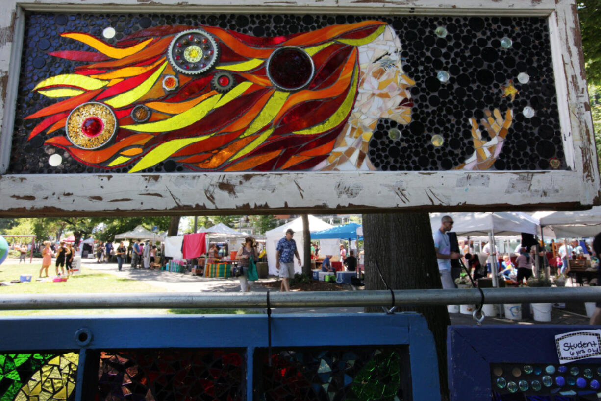 The Sunday market is seen beneath a stain glass artwork at the annual Recycled Art Fair in Esther Short Park in downtown Vancouver on Sunday.