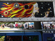 The Sunday market is seen beneath a stain glass artwork at the annual Recycled Art Fair in Esther Short Park in downtown Vancouver on Sunday.