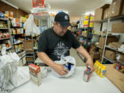 Volunteer Steve Goodin sorts through donated food Thursday evening at the new location of Martha&#039;s Pantry in Vancouver Heights United Methodist Church.