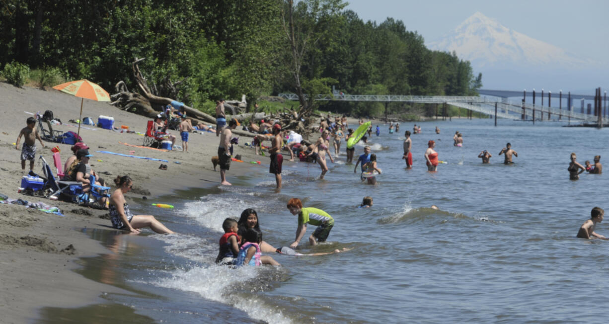 Swimmers cool off Sunday in the Columbia River at Wintler Park in Vancouver. The park was a popular destination for people seeking relief from the hot weather.