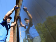 Steve Powers of Vancouver&#039;s Maplewood Neighborhood Association helps a neighbor with home maintenance Saturday morning. Volunteers cleaning graffiti off the house decided to use association funds to repaint the whole thing.