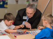 Development of Early Learning Director Ross Hunter learns about fire from students at Kidspace Child Enrichment Center, which is still undergoing renovations after a fire in January.