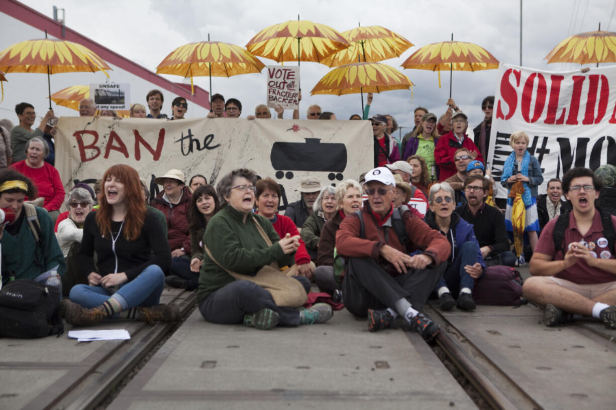 Approximately 100 people, some with sunflower umbrellas, joined in an anti-fossil fuel protest near the Vancouver Amtrak station on Saturday.