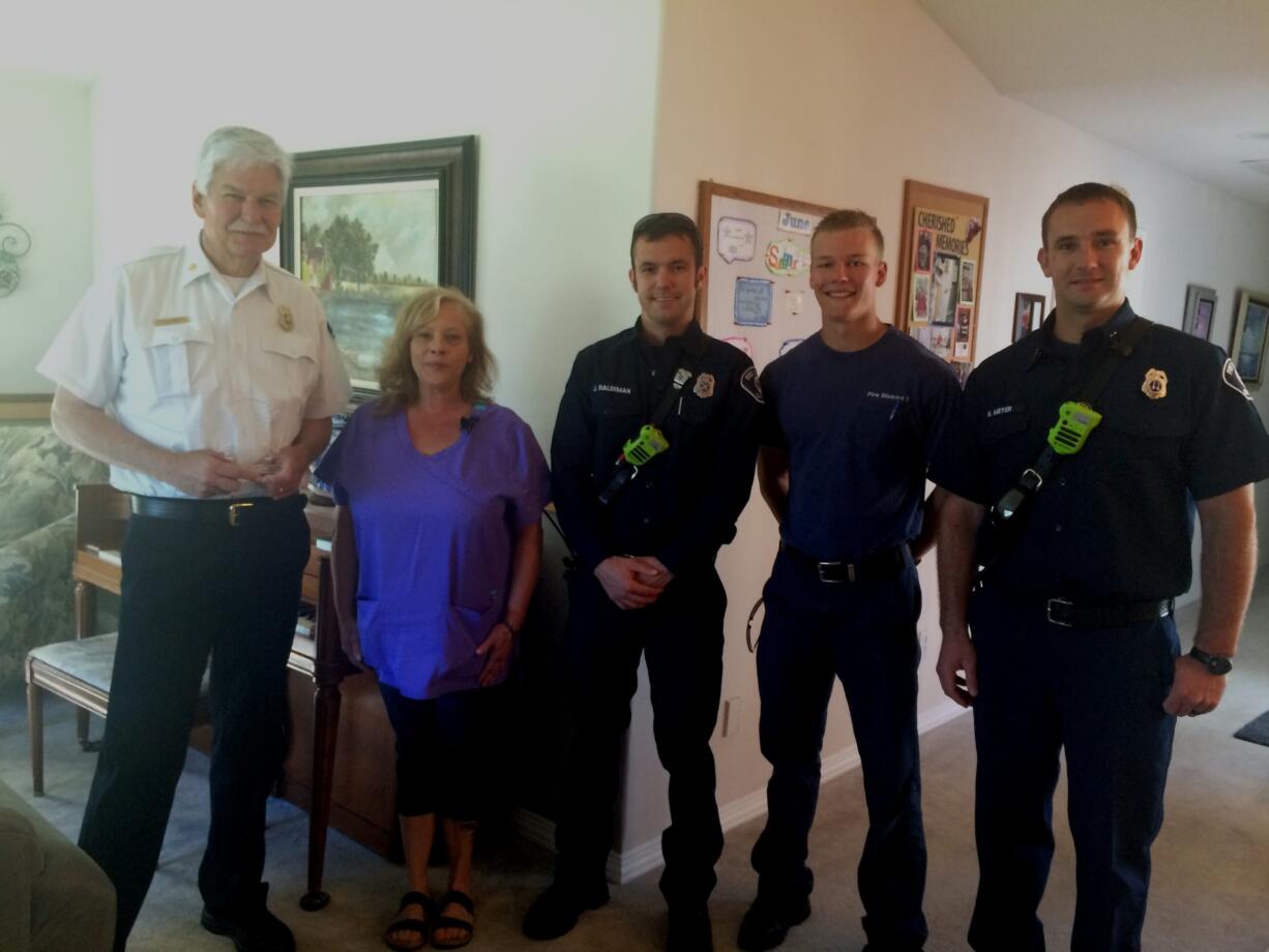 Donna Welker, second from left, with Clark County Fire District 3 Chief Steve Wrightson and the district's Josh Haldeman, Jens Tapio and Nolan Meyer. The district honored Welker this week for her efforts to help a choking woman in Battle Ground in May.