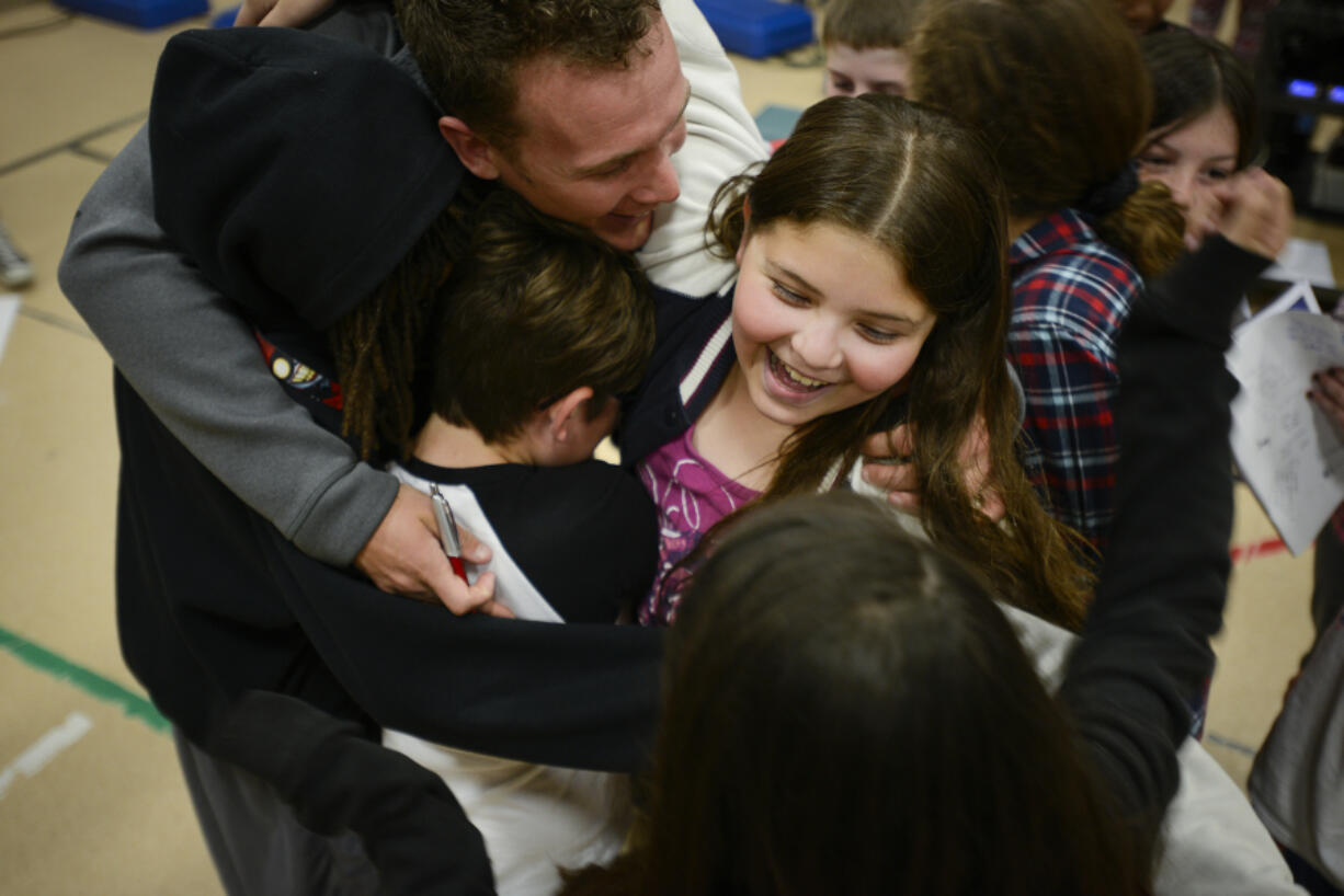 Fifth-grader Alicia Zuniga participates in a group hug with professional endurance athlete Colin O&#039;Brady at Hearthwood Elementary on Wednesday. O&#039;Brady summited the tallest mountain in each of the seven continents and skied to the North and South poles. His next goal: raising $1 million to inspire active, healthy kids with his foundation, Beyond 7/2.