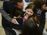 Fifth-grader Alicia Zuniga participates in a group hug with professional endurance athlete Colin O&#039;Brady at Hearthwood Elementary on Wednesday. O&#039;Brady summited the tallest mountain in each of the seven continents and skied to the North and South poles. His next goal: raising $1 million to inspire active, healthy kids with his foundation, Beyond 7/2.