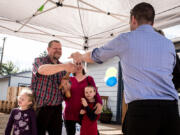 Chris Tandberg, left, with his family, accepts the keys to his family&#039;s new home from Evergreen Habitat for Humanity Executive Director Josh Townsley, right, on Friday.