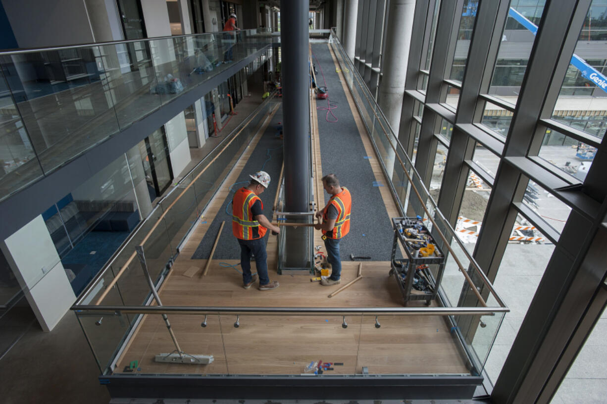 Igor Tsvor, left, and Viktor Vakulchik of Legend Custom Woodworking lend a hand to the construction of the dog ramp Wednesday afternoon at Banfield Pet Hospital. Employees will start moving into the new headquarters this week.