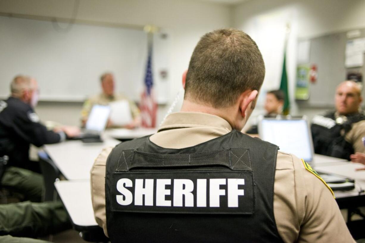 New Clark County Sheriff recruit Ethan Ogdee, center, listens during a meeting before the graveyard shift at the Clark County Sheriff West Precinct in Ridgefield on April 15.