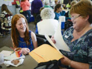 Laurie Johnson, right, looks Monday at a handwritten letter from Paige Armstrong, left, a fifth-grader at Endeavour Elementary School.