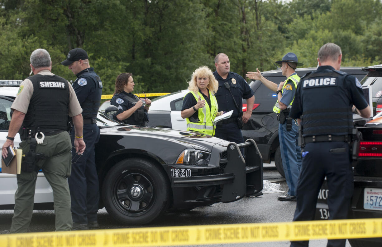 Police and emergency personnel at the scene of a shooting west of Battle Ground Monday June 13, 2016. A man accused of robbing a downtown Vancouver bank was cornered west of Battle Ground, where he was apparently shot.