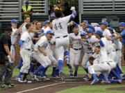 UC Santa Barbara's Austin Bush (44) crosses home plate as his teammates celebrate after Bush hit a walk-off home run against Washington in the 14th inning of an NCAA college baseball regional tournament game Friday, June 3, 2016, in Nashville, Tenn. The home run gave UC Santa Barbara a 3-2 win.