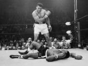 In this May 25, 1965, photo, heavyweight champion Muhammad Ali, then known as Cassius Clay, stands over challenger Sonny Liston, shouting and gesturing shortly after dropping Liston with a short hard right to the jaw, in Lewiston, Maine. Ali, the magnificent heavyweight champion whose fast fists and irrepressible personality transcended sports and captivated the world, has died according to a statement released by his family Friday, June 3, 2016. He was 74.