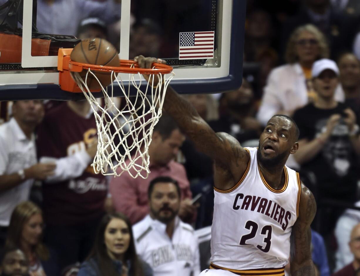 Cleveland Cavaliers forward LeBron James (23) dunks against the Golden State Warriors during the second half of Game 3 of basketball's NBA Finals in Cleveland, Wednesday, June 8, 2016.