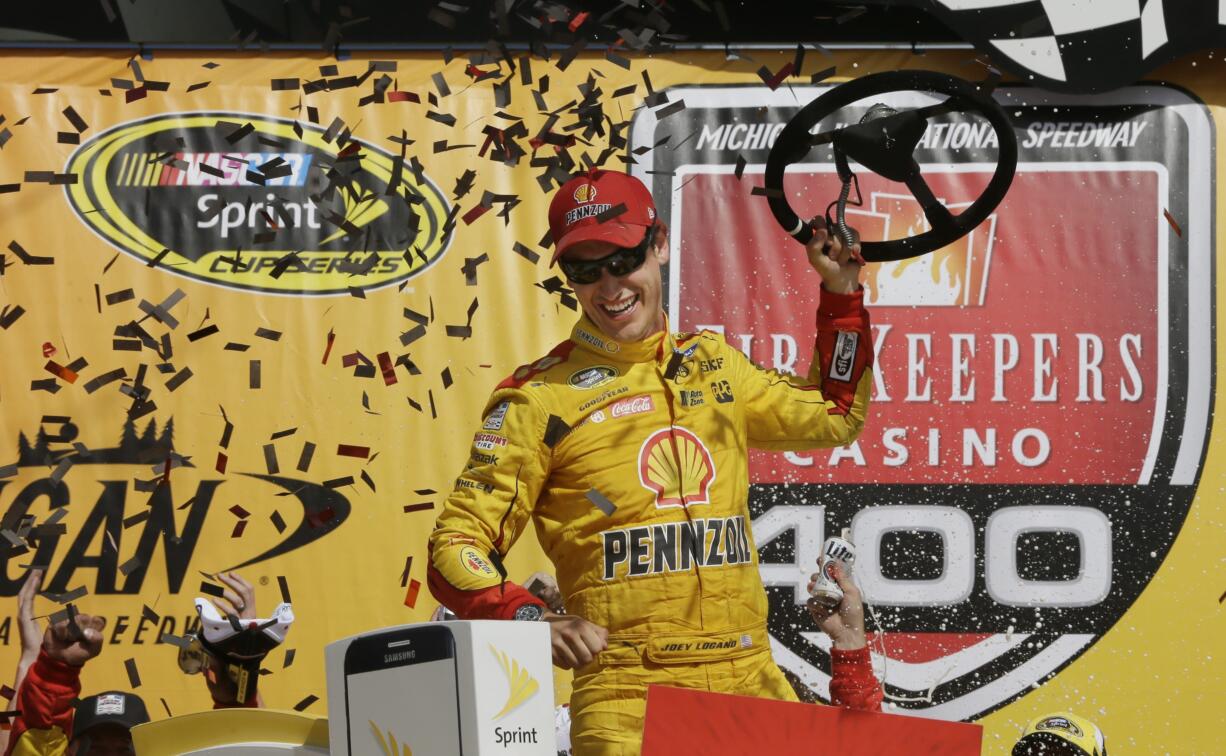 Joey Logano celebrates after winning the NASCAR Sprint Cup series auto race at Michigan International Speedway, Sunday, June 12, 2016 in Brooklyn, Mich.