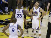 Golden State Warriors guard Stephen Curry (30), forward LeBron James (23) and forward Andre Iguodala (9) stand on the court as Cleveland Cavaliers forward LeBron James, on ground, is tended to during the second half of Game 7 of basketball's NBA Finals in Oakland, Calif., Sunday, June 19, 2016. The Cavaliers won 93-89.