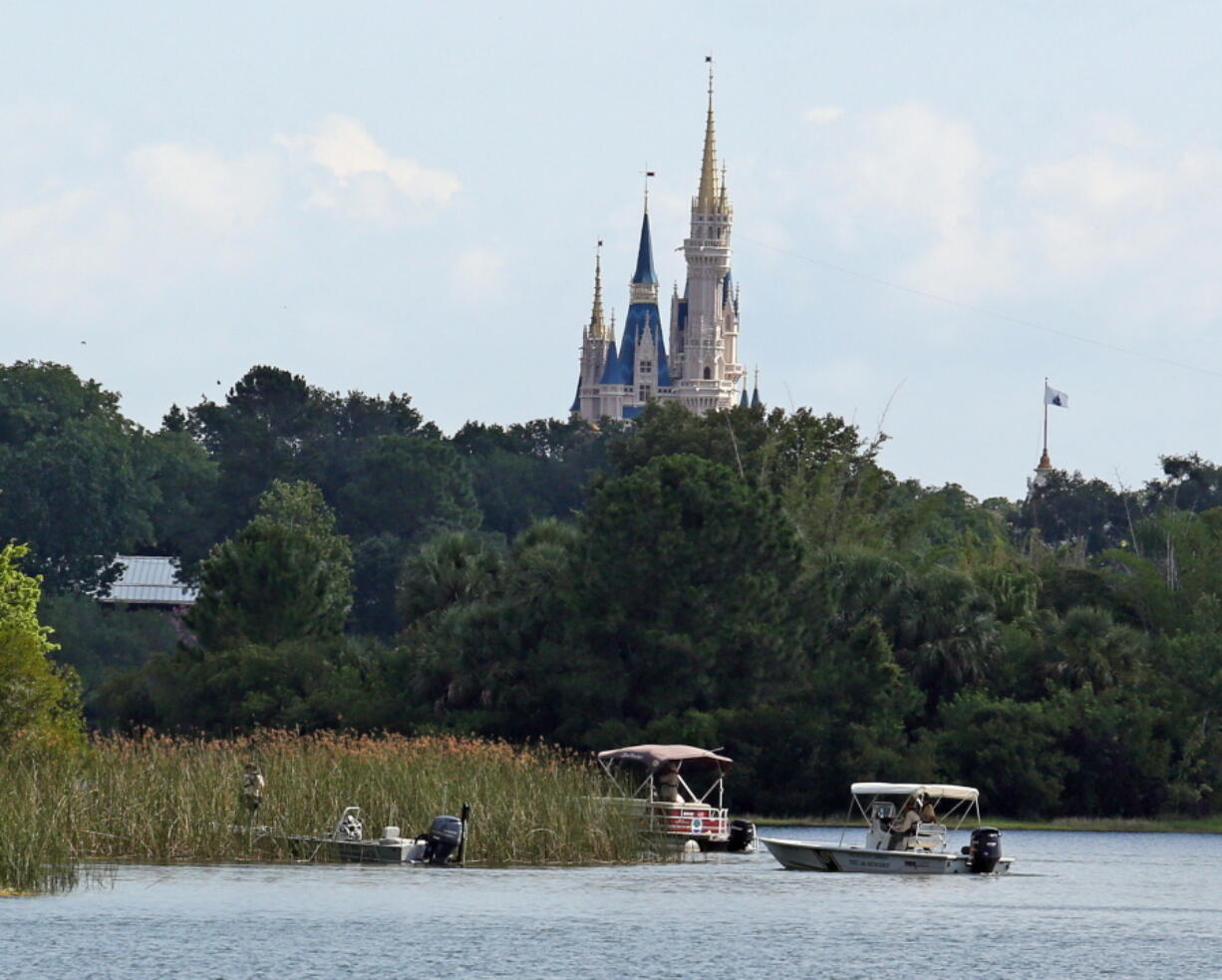 In the shadow of the Magic Kingdom, authorities search on June 15 for the body of a boy who was dragged away by an alligator at Grand Floridian Resort at Disney World in Lake Buena Vista, Fla.