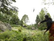 Ryan Dehn, a fishmonger from Pike Place Fish Market, tosses a salmon to grizzly bears Thursday at the Woodland Park Zoo in Seattle. The famous fish-throwers were on hand to feed the bears and promote the zoo&#039;s upcoming Bear Affair conservation day Saturday and Washington state&#039;s Bear Awareness Week, June 4-12. (Photos by Ted S.