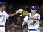 Seattle Mariners relief pitcher Edwin Diaz, left, reaches out to congratulate third baseman Kyle Seager on a play in the eighth inning of a baseball game against the St. Louis Cardinals Saturday, June 25, 2016, in Seattle.