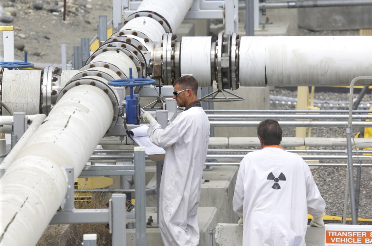 Workers wearing protective clothing inspect a valve at the &quot;C&quot; tank farm July 9, 2014, on the Hanford Nuclear Reservation near Richland. The Hanford Atomic Metal Trades Council on Monday issued a list of demands to the U.S. Department of Energy and its tank farm contractor, Washington River Protection Solutions.