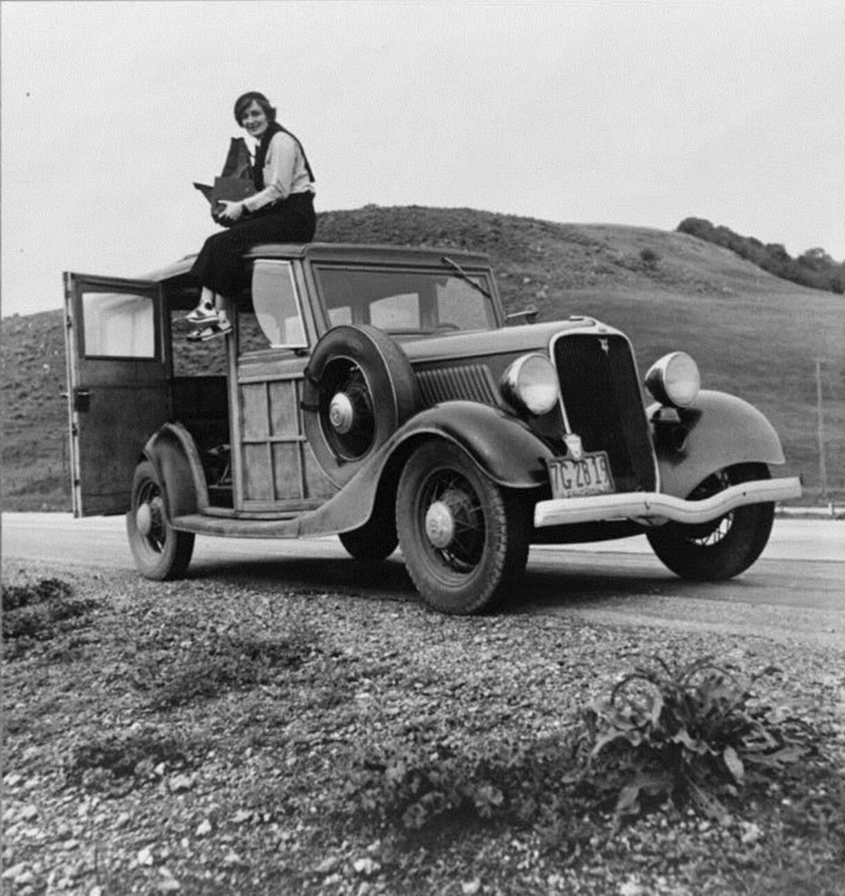 This 1936 image shows Resettlement Administration photographer Dorothea Lange sitting atop a vehicle in California. Lange is among the women whose stories are featured as part of The Women on the Mother Road project, a partnership between Cinefemme and the National Park Service to highlight women&#039;s experiences along historic Route 66.