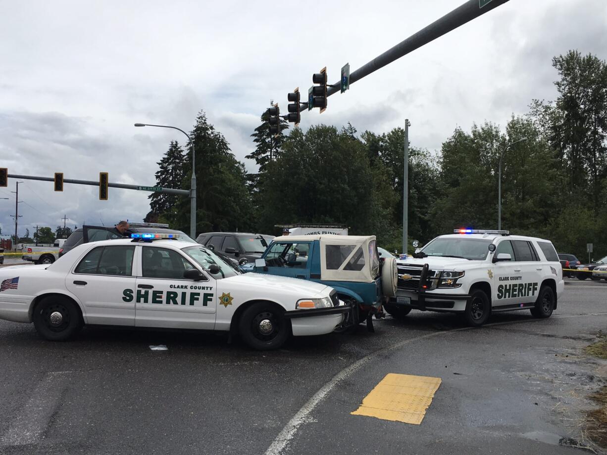 Police cars block an SUV apparently driven by a bank robbery suspect at the intersection of Northeast 10th Avenue and 219th Street. The suspect was reported to have been shot.