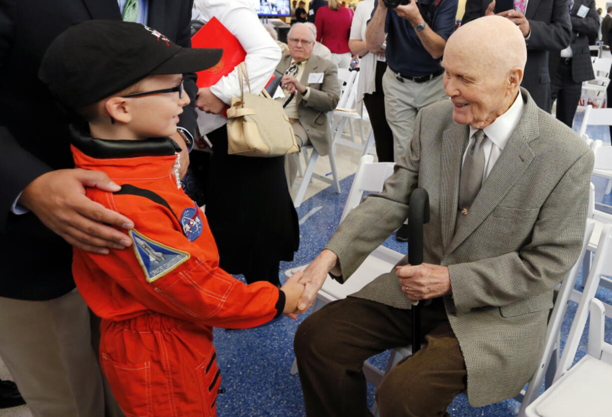 John Glenn shakes hands with 8-year-old Josh Schick before the start of Tuesday&#039;s airport renaming celebration in Columbus, Ohio.