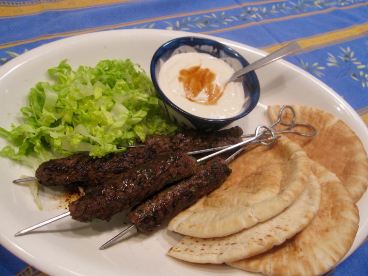 Grilled Ground Lamb Kebabs served with a garlicky tahini/yogurt sauce and a pita pocket.