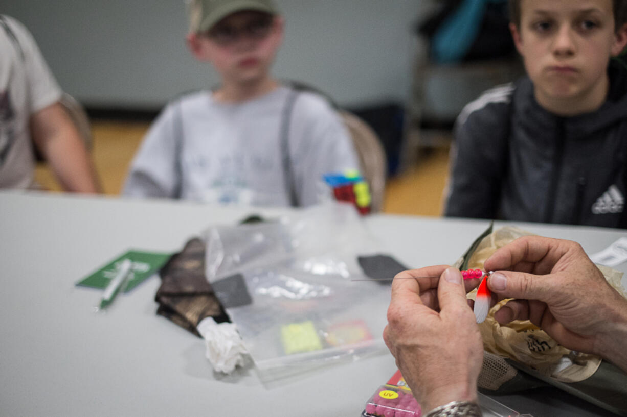 Laurin Middle School students watch teacher Darrell Kirkpatrick demonstrate how to tie a fishing lure during an after-school fishing class offered by Battle Ground Public Schools.