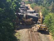 Crews work to right oil tanker cars Saturday afternoon following Friday's derailment and fire near the Oregon community of Mosier in the Columbia River Gorge.