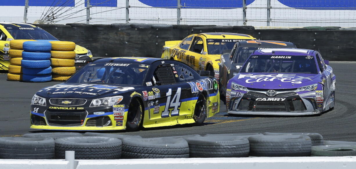 Tony Stewart, left, leads Denny Hamlin through Turn 11 during the NASCAR Sprint Cup Series auto race Sunday, June 26, 2016, in Sonoma, Calif.