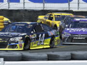 Tony Stewart, left, leads Denny Hamlin through Turn 11 during the NASCAR Sprint Cup Series auto race Sunday, June 26, 2016, in Sonoma, Calif.