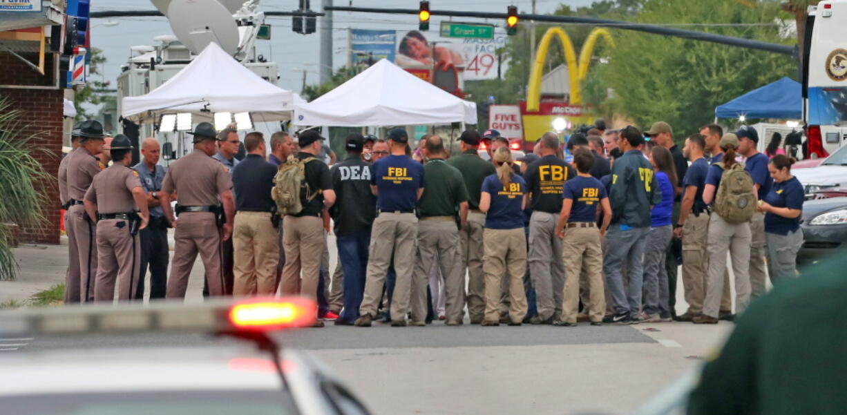 Multiple law enforcement agencies gather early Monday in front of  Pulse Nightclub at the mass shooting scene in Orlando. Federal investigators promised to provide more insight as to what was happening inside the Pulse nightclub after a gunman started a deadly assault that was the worst mass shooting in modern U.S. history.